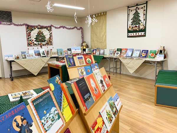 写真：クリスマス展示の様子。クリスマスの本や、クリスマスツリー模様の壁飾りが並んでいます。
