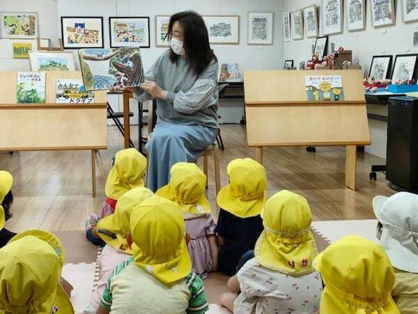 写真：当館スタッフが幼稚園児に読み聞かせをしています。