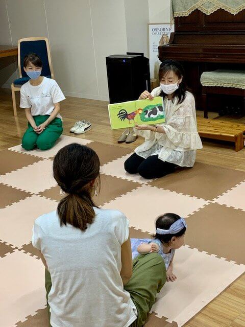 写真：フリーアナウンサーの清水さんが未就園児に絵本をよんでいます。