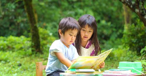 写真：男の子と女の子が本を読んでいます。