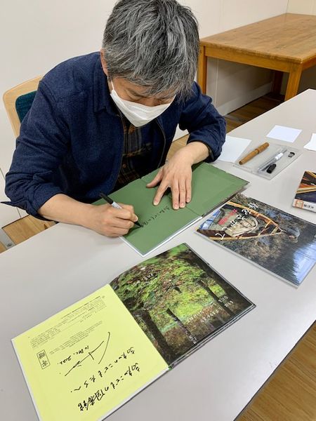 写真：写真家大竹英洋さんがサインをしてくださっています。