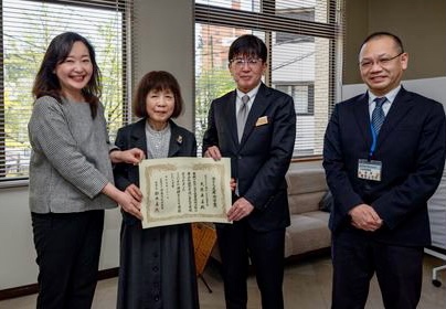 写真：当館初代館長大原と職員の大木、高知県長岡教育長が功労賞の賞状を持っています。