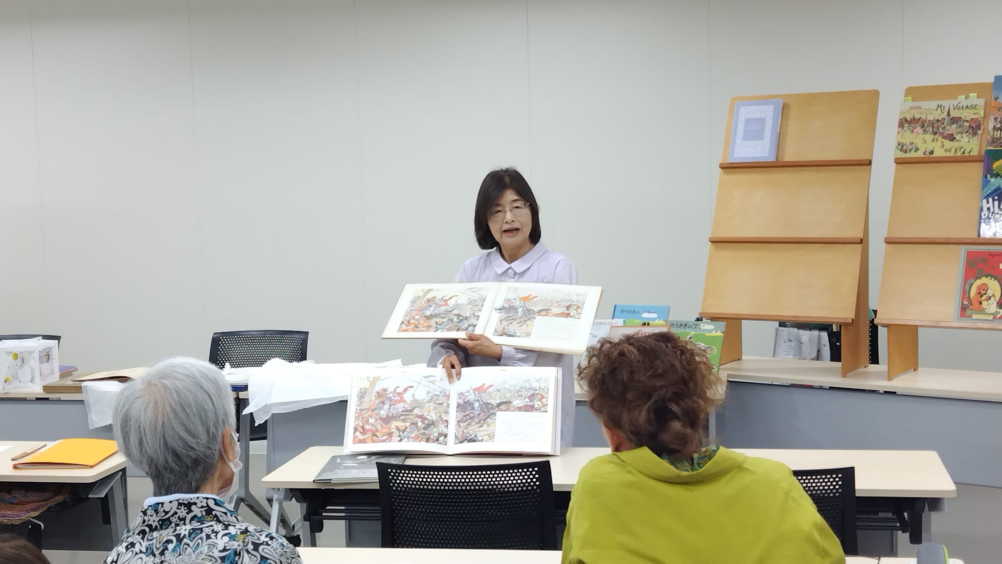 写真：安田幸子先生が絵本を見せながら講義をしています。