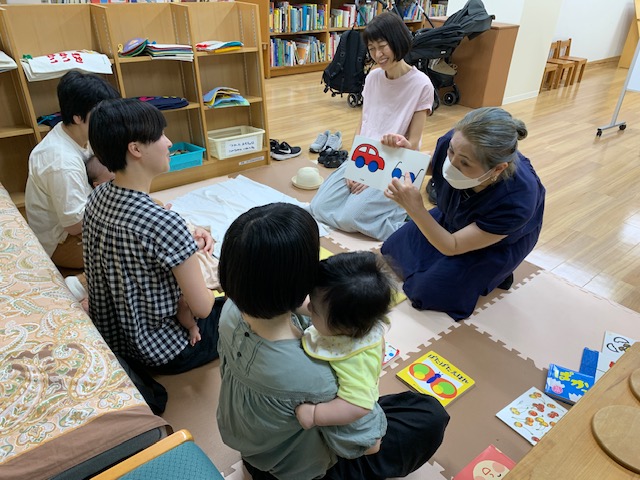 写真：赤ちゃんと保護者に布絵本を読んでいます。