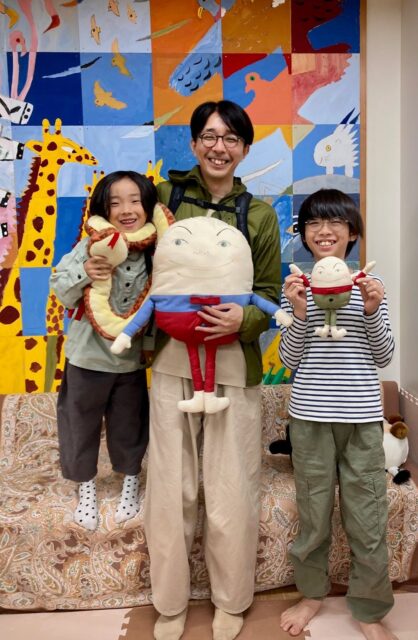 写真：園部信教さんとお子さんです。ハンプティダンプティの人形を持っています。