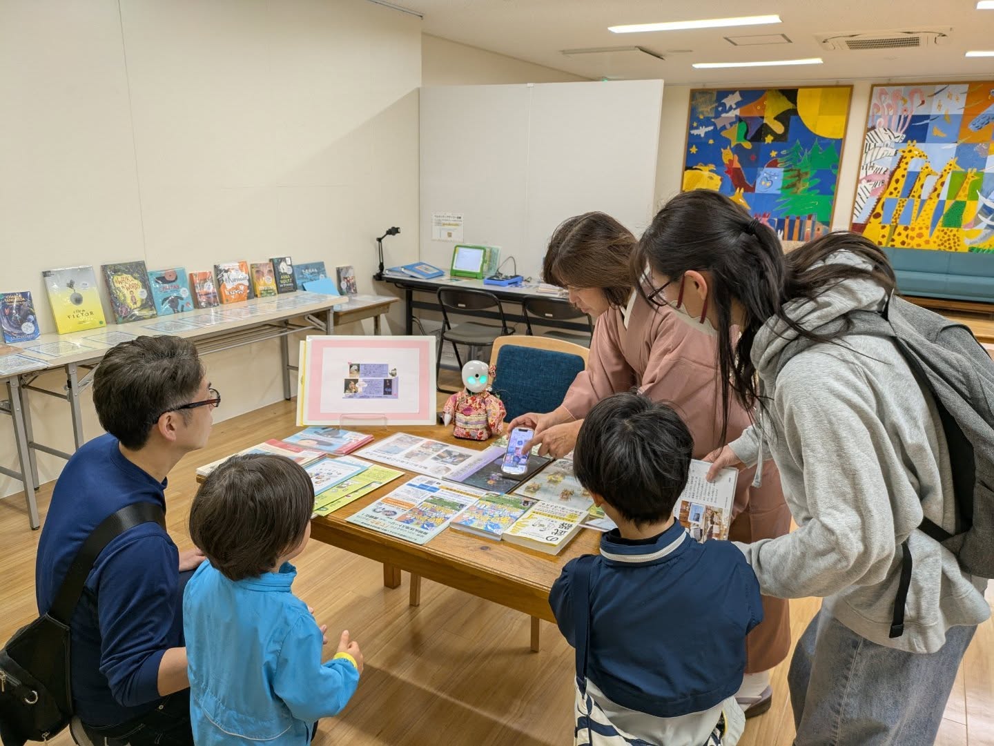 写真：図書館に来てくれた人とオリヒメが会話しています。