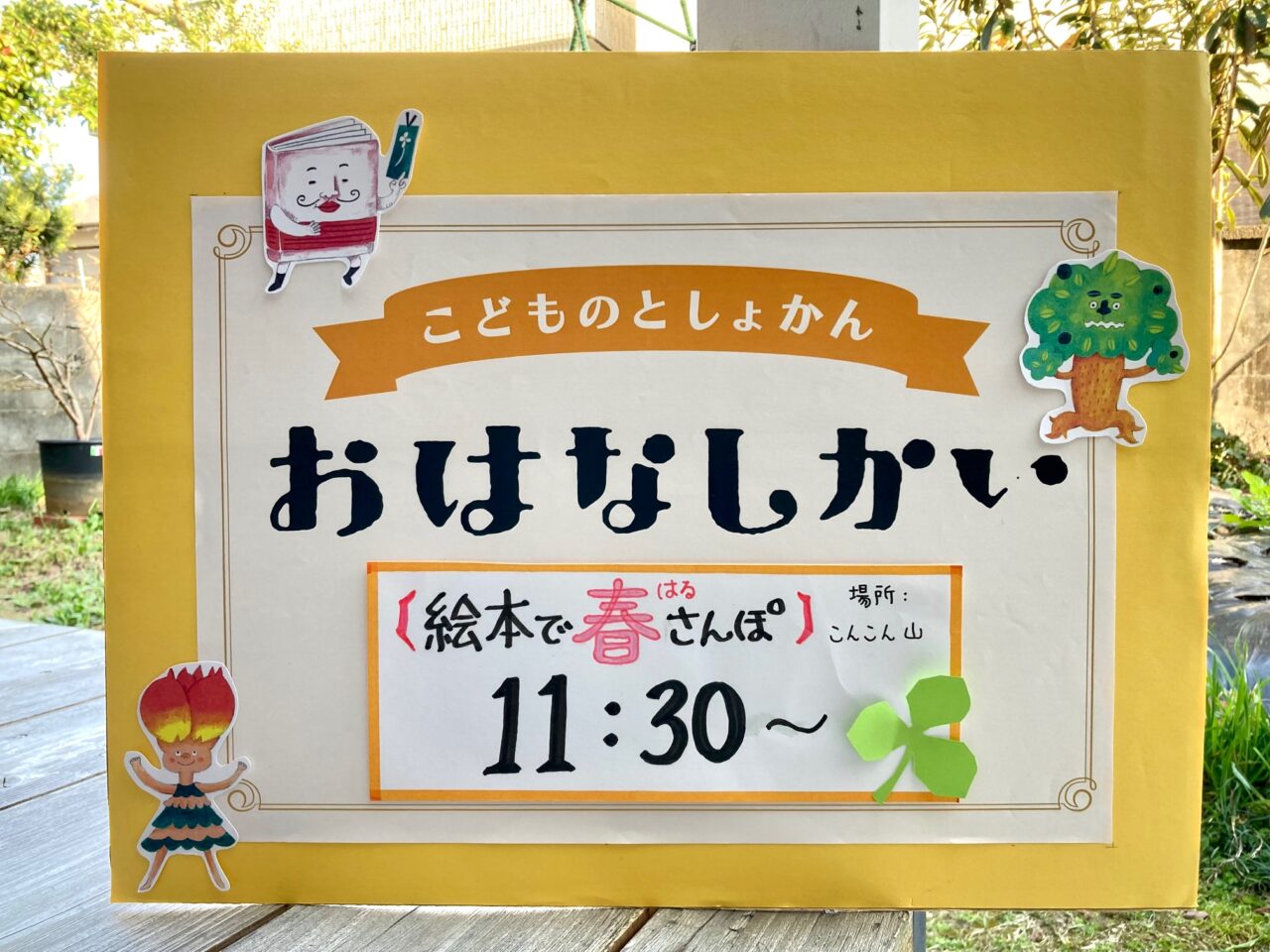 写真:こどもの図書館のおはなし会のお知らせボードです。テキスト:絵本で春さんぽ11:30〜
