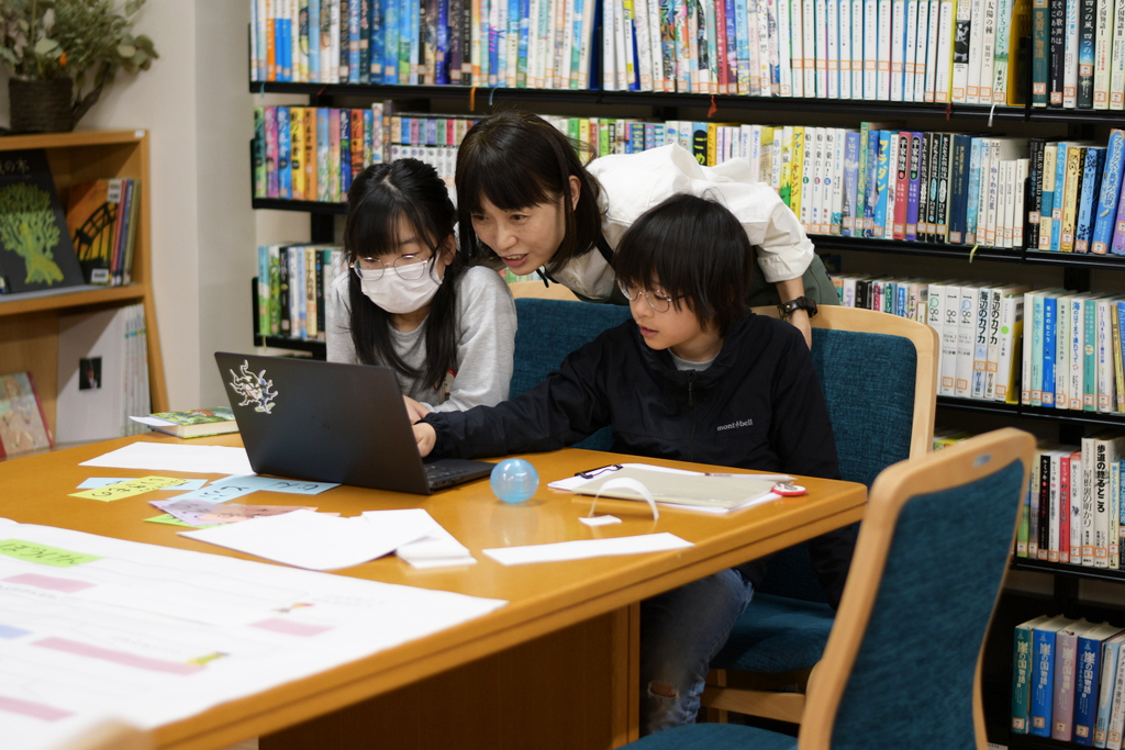 写真:子どもたちとスタッフ堀内が相談しています