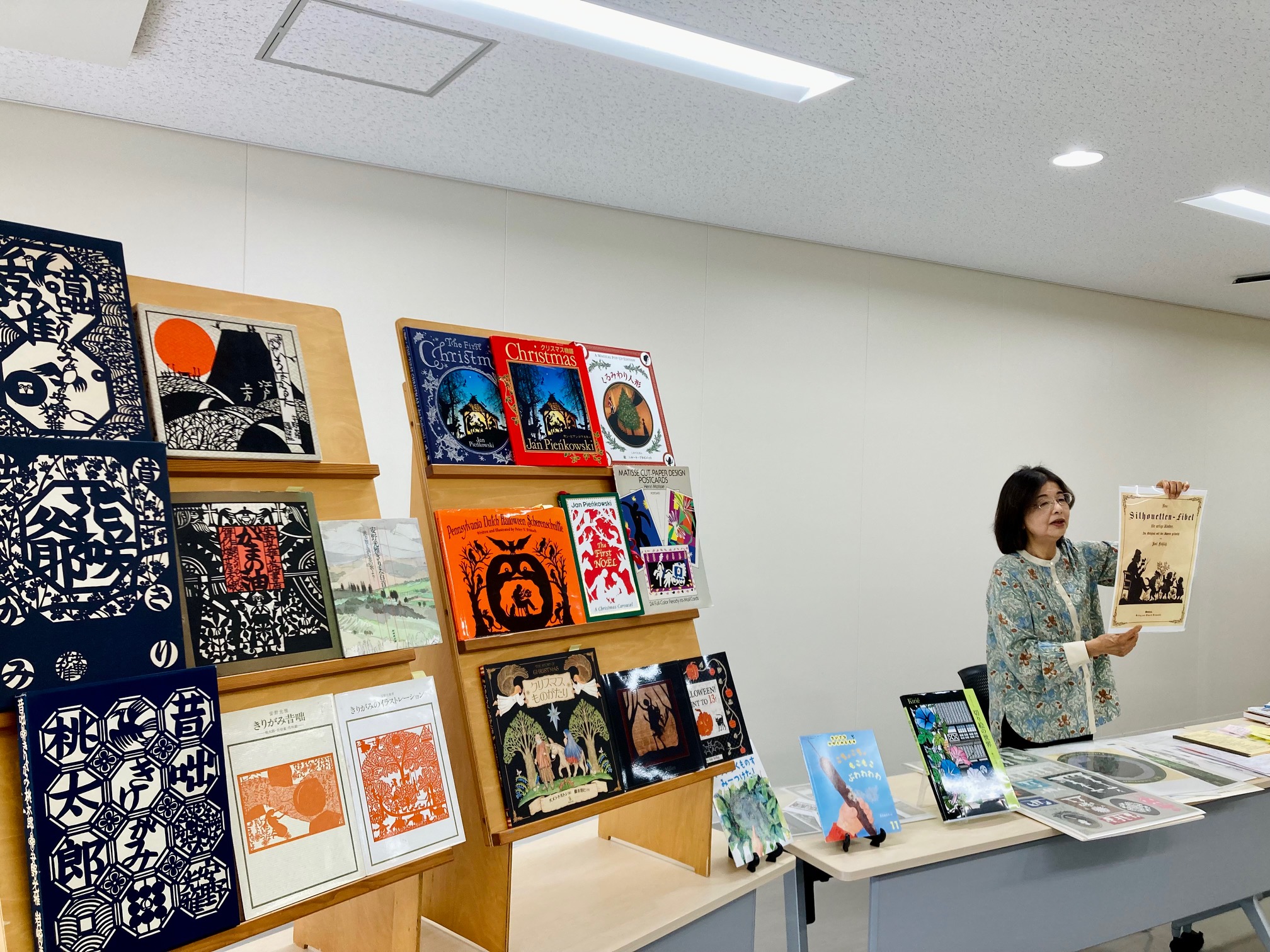写真：安田さんが切り絵の絵本を手に持って説明しています。