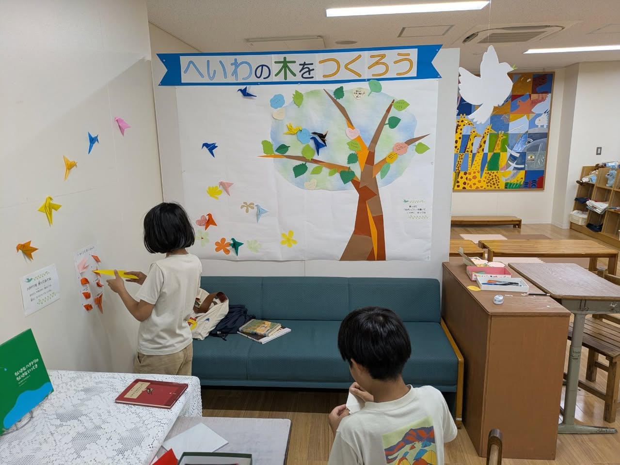 写真：子ども2人がハチドリを壁に貼ってくれています