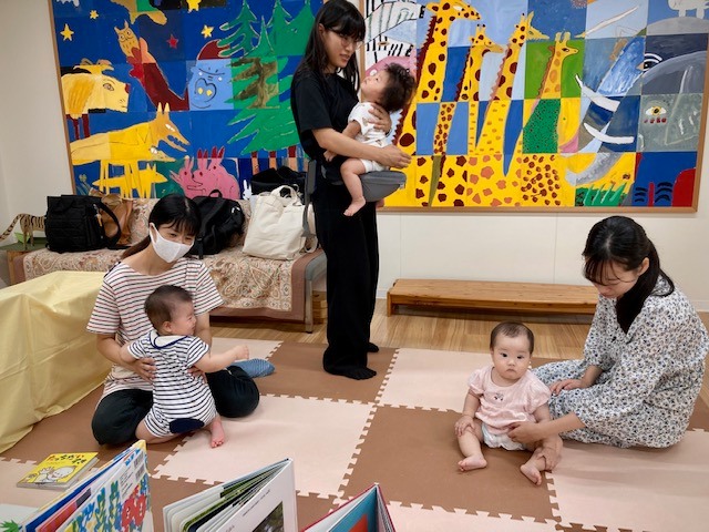 写真：赤ちゃんがお母さんに抱っこされています