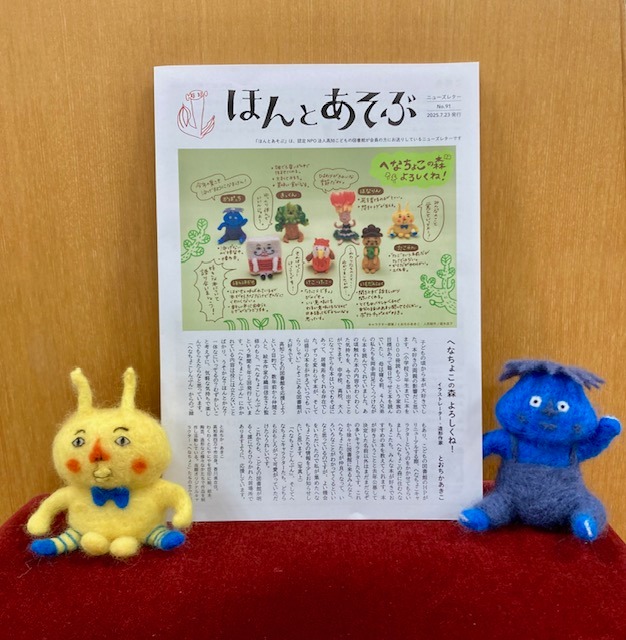 写真：ニューズレターが椅子の上に置かれています。傍にへなちょこキャラクターのぬいぐるみが置かれています