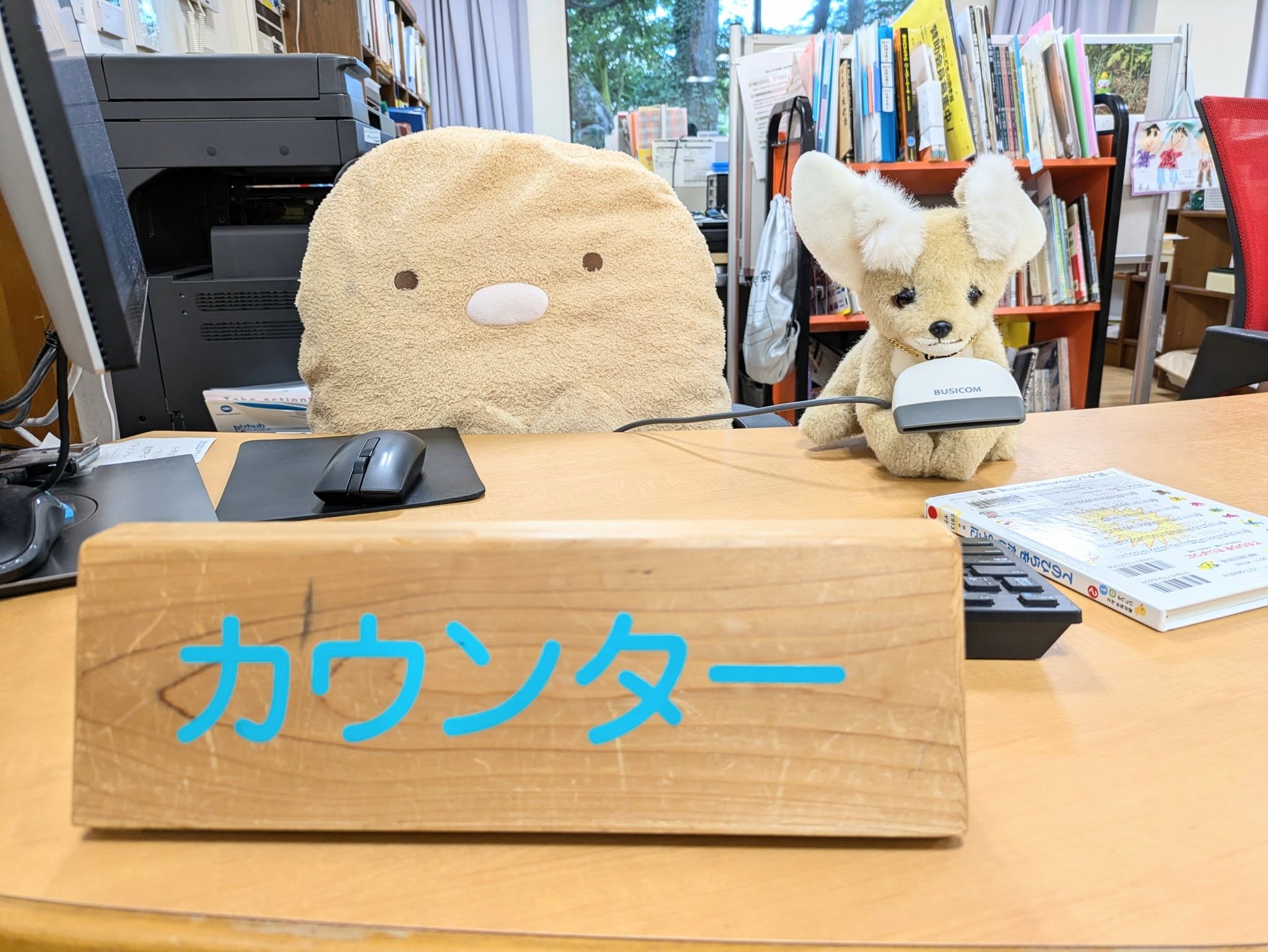 写真：ぬいぐるみが図書館のカウンターに座っています