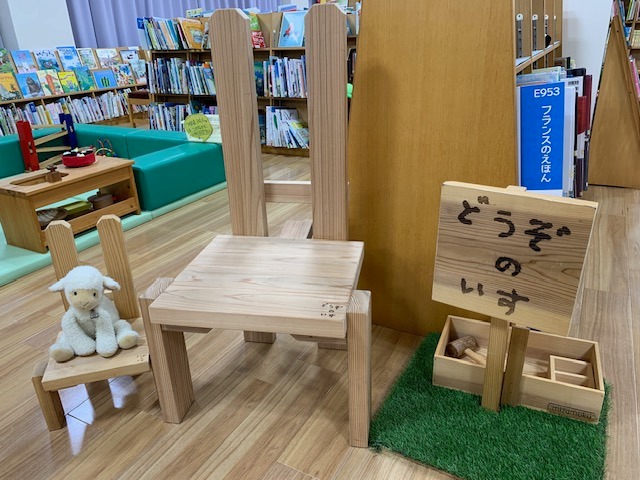 写真：いすが二脚並んでいます。小さい椅子の上に羊のぬいぐるみがいます。