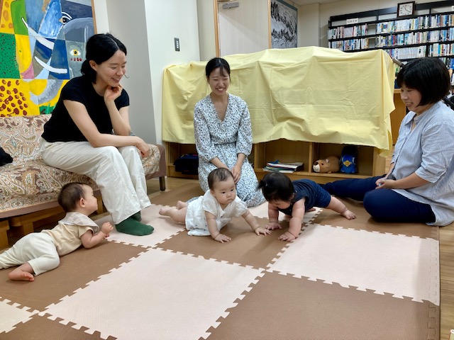 写真：３人の赤ちゃんとお母さんが談笑しています。