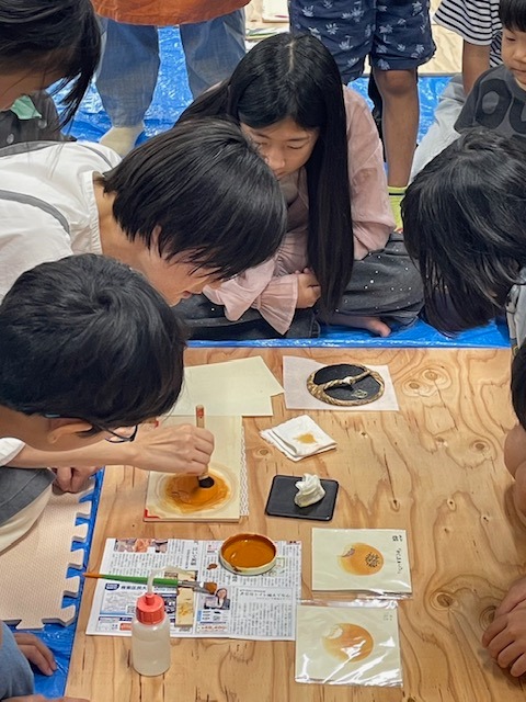 写真：彦坂有紀さんが木版画の実演をしています