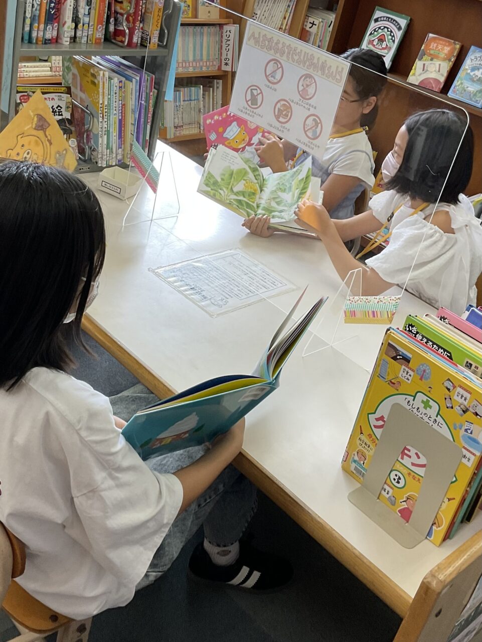 写真：参加者の小学生が絵本を読み合っています