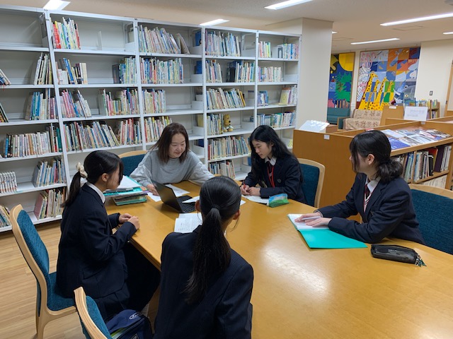 写真：大木館長と国際中学校の学生さん4名が話しています。