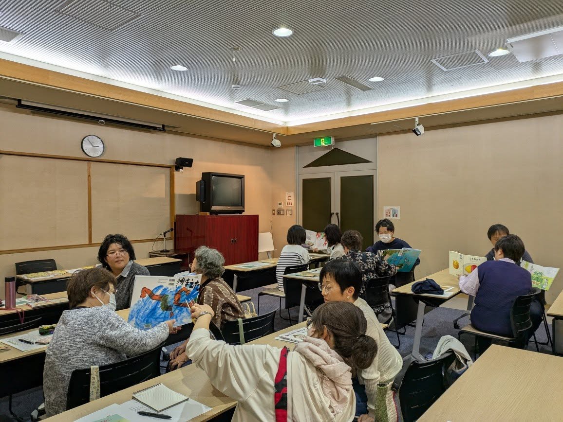 写真:参加者が絵本を読み合っています