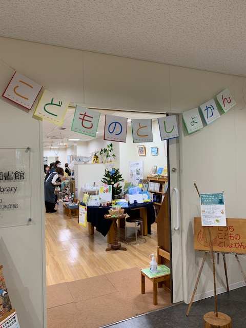 写真：図書館の入り口から、館内が見えます。人で賑わっています