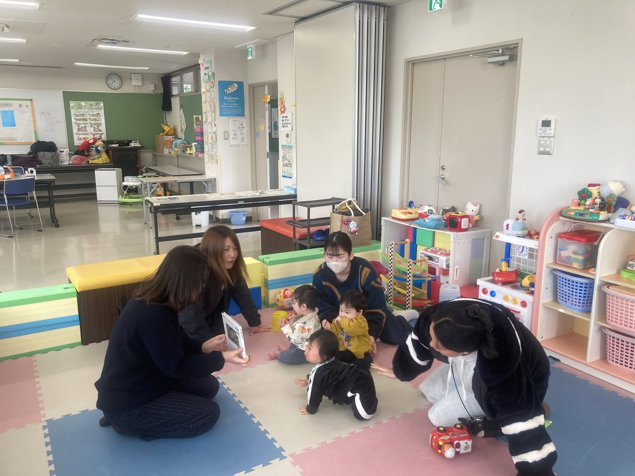 写真：館長の大木が親子に絵本を読んでいます