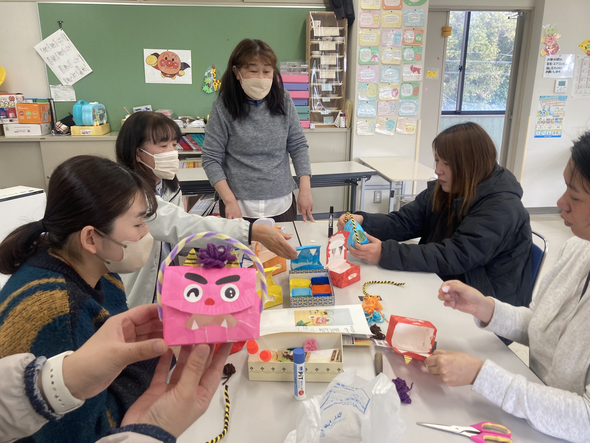 写真：利用者が節分の豆入れの工作をしています。