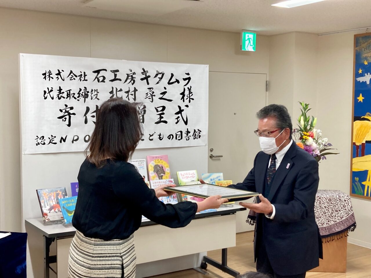 写真:北村様から館長大木に目録を贈呈しています。