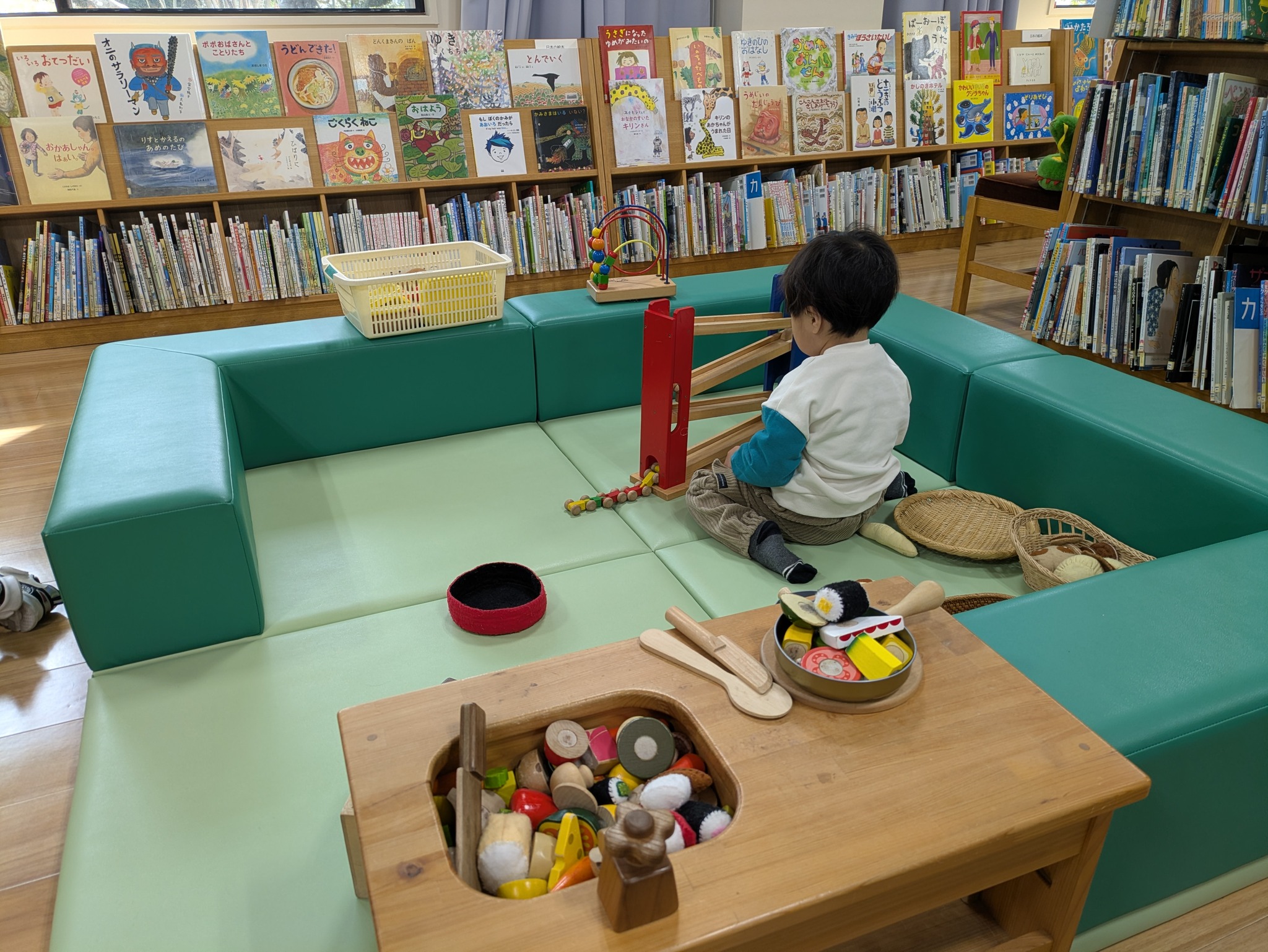 写真：男の子が木のおもちゃで遊んでいます